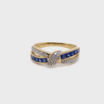 9CT YELLOW GOLD CROSS OVER DIAMOND & SAPPHIRE DRESS RING VALUED @ $1399